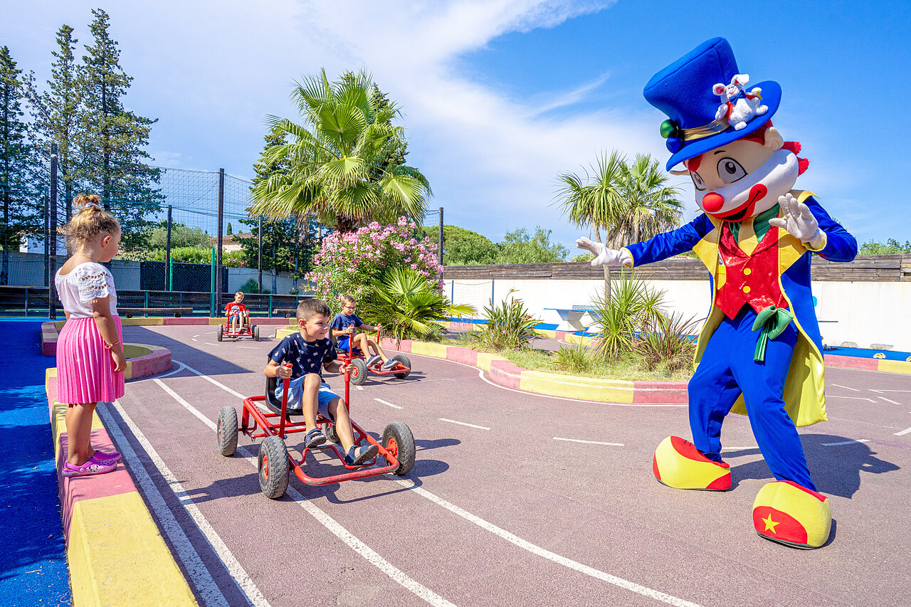 Enfants en karts � p�dales avec mascotte sur piste au camping CAPFUN Aubr�des � Puget sur Argens (83).