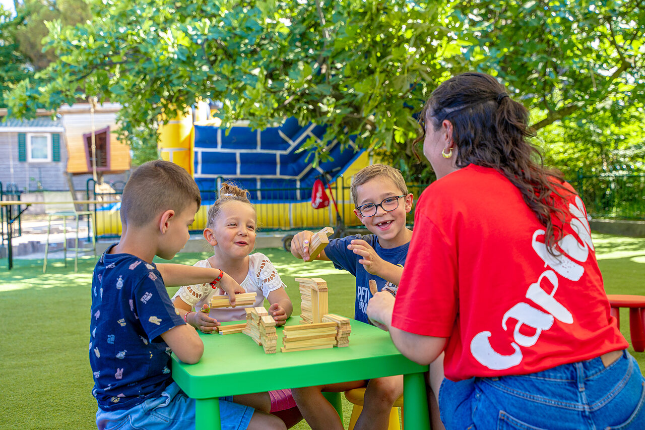 Enfants jouant � des jeux de construction avec animateur au camping CAPFUN Aubr�des (83).
