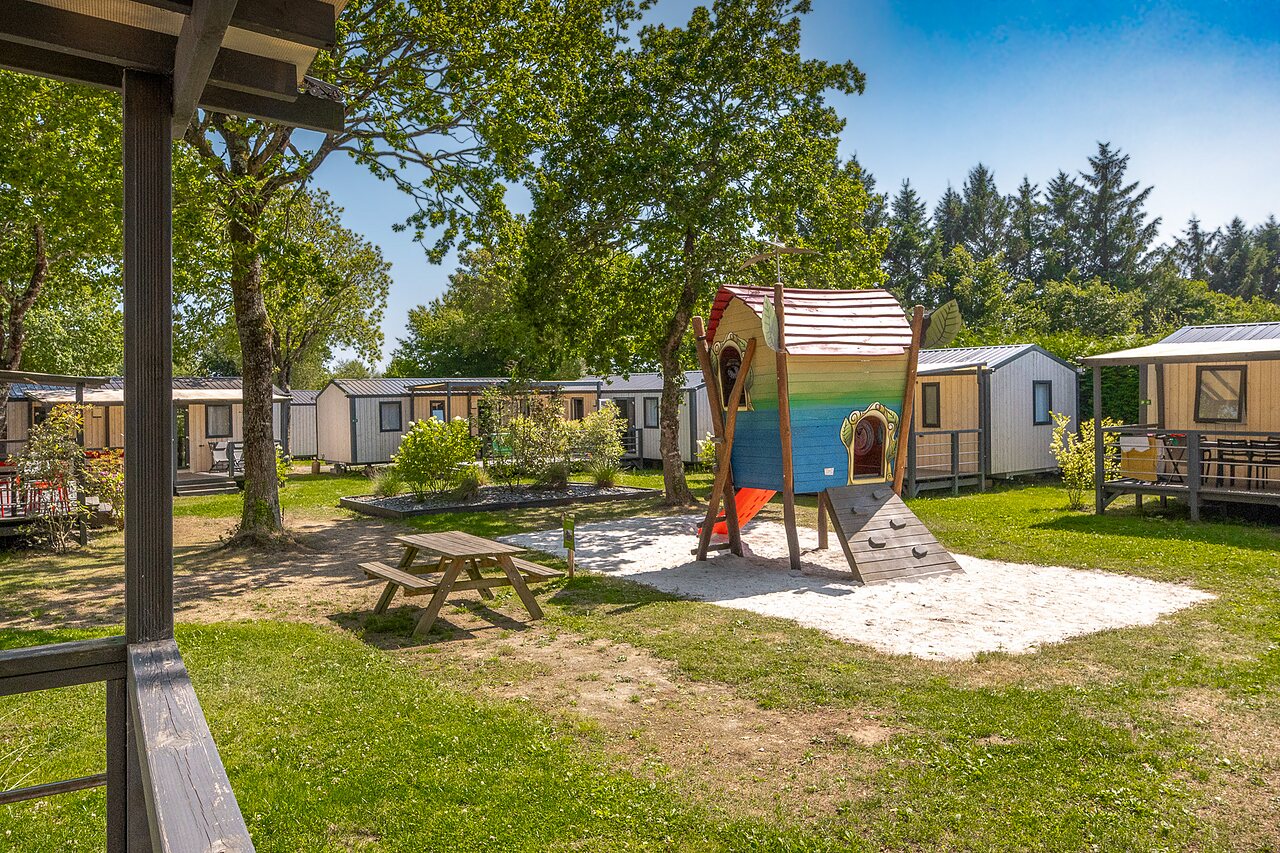 Aire de jeux enfants, cabane, toboggan et mobile-homes au camping CLICOCHIC � Poullan-sur-Mer.