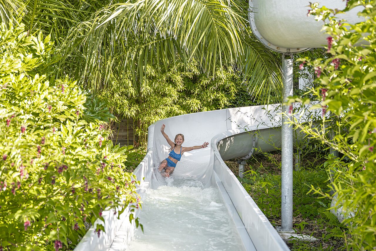 Enfant souriante sur toboggan aquatique au camping CLICOCHIC Baie de Douarnenez � Poullan-sur-Mer.