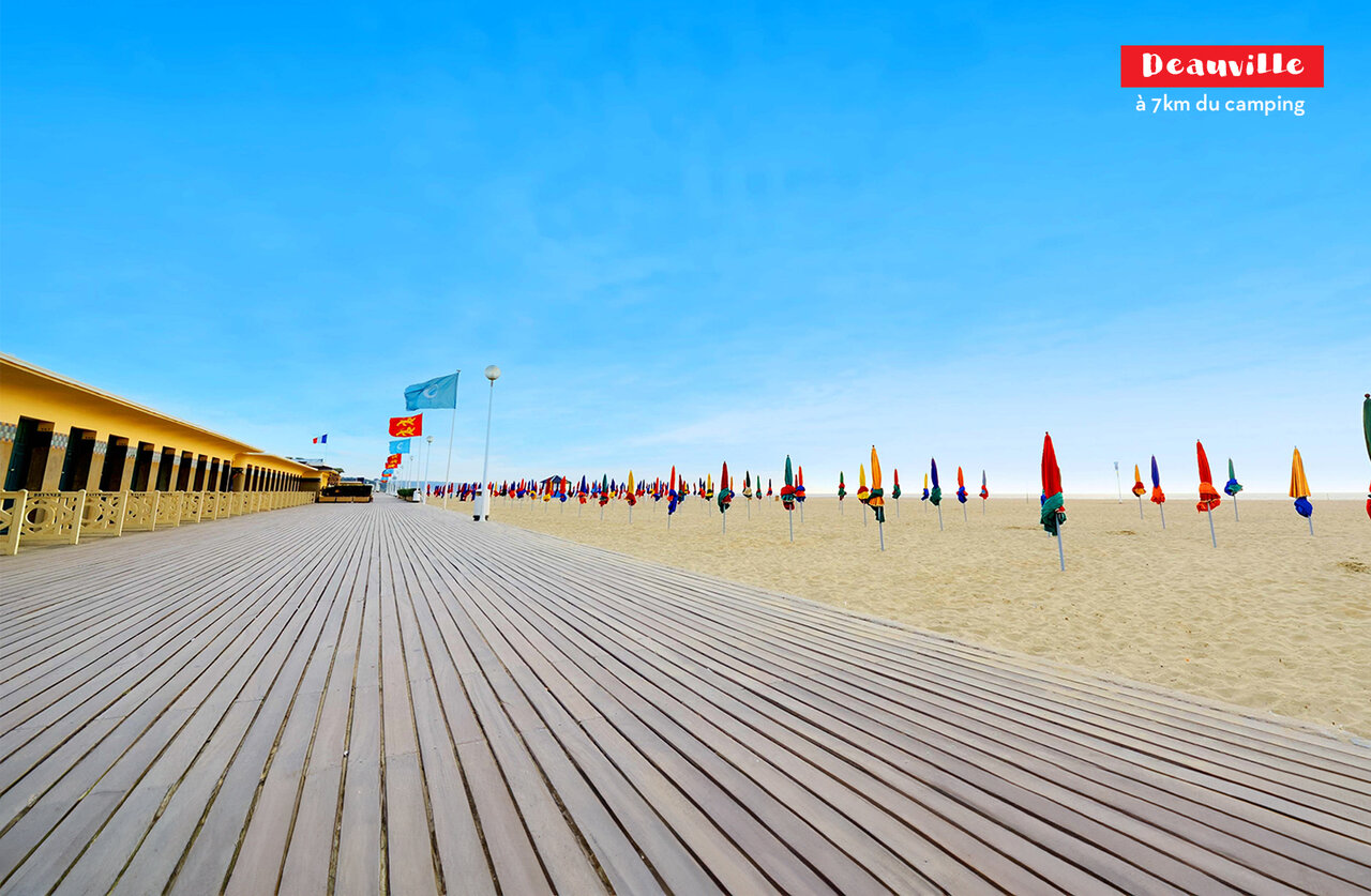 Planches de Deauville, c�l�bres cabines et parasols color�s sur la plage normande.