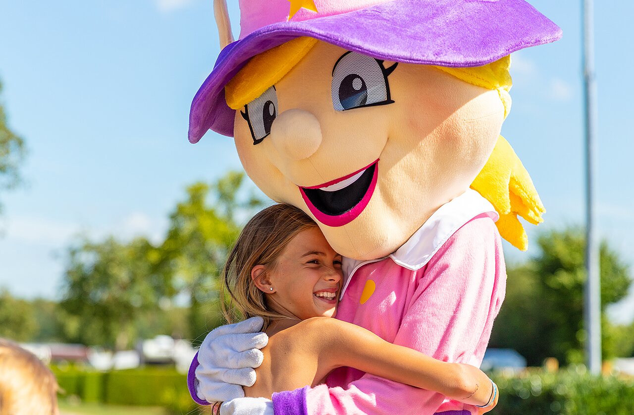 Enfant souriant �treignant la mascotte du camping CAPFUN Montsabert � COUTURES (49).