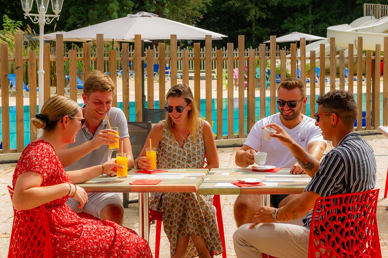 Amis buvant au bar, piscine en arri�re-plan, camping CAPFUN Montsabert � COUTURES (49).