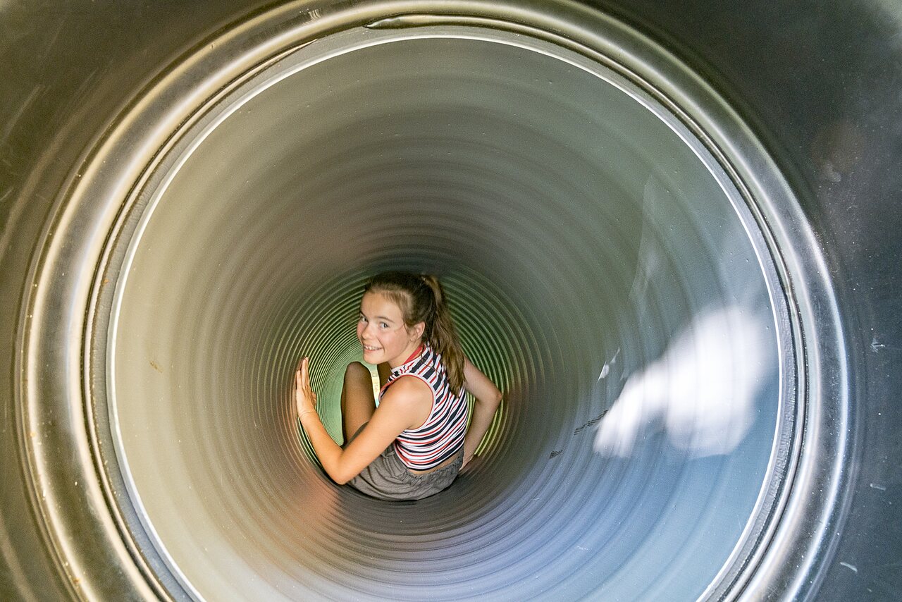 Fille souriante s'amusant dans un toboggan tubulaire au camping CAPFUN Montsabert � COUTURES (49).