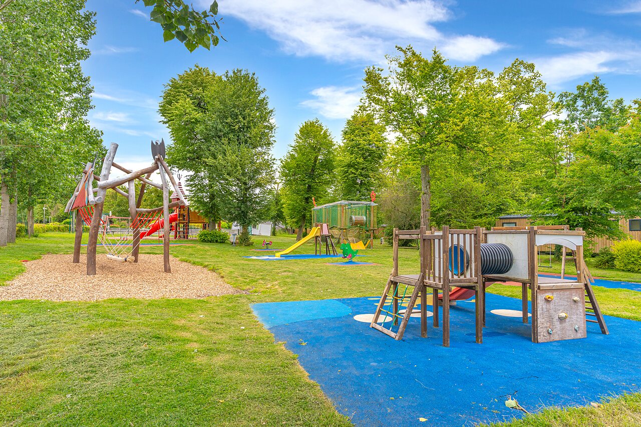 Aire de jeux ext�rieure avec toboggans, structures en bois et balan�oires au camping CAPFUN Parc de Paris � Villevaud� (77).