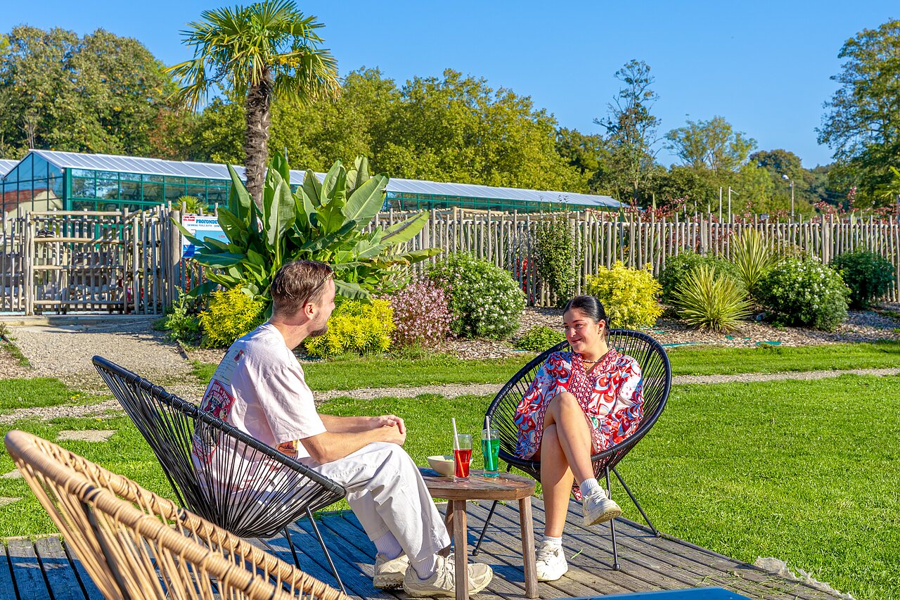 Couple se d�tendant pr�s de la piscine ext�rieure au camping CAPFUN Parc de Paris � Villevaud� (77).